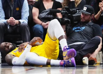 LeBron James grimaces in pain after falling while going up for a basket past Nikola Jokić during the fourth quarter of the Lakers' 120-113 loss to the Nuggets in Denver on March 5, 2026.