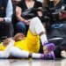 LeBron James grimaces in pain after falling while going up for a basket past Nikola Jokić during the fourth quarter of the Lakers' 120-113 loss to the Nuggets in Denver on March 5, 2026.