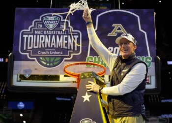 Akron head coach John Groce waves the net after Akron defeated Toledo in an NCAA college basketball game in the championship of the Mid-American Conference tournament, Saturday, March 14, 2026, in Cleveland.