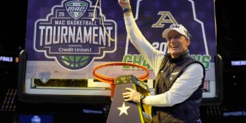 Akron head coach John Groce waves the net after Akron defeated Toledo in an NCAA college basketball game in the championship of the Mid-American Conference tournament, Saturday, March 14, 2026, in Cleveland.
