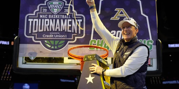Akron head coach John Groce waves the net after Akron defeated Toledo in an NCAA college basketball game in the championship of the Mid-American Conference tournament, Saturday, March 14, 2026, in Cleveland.