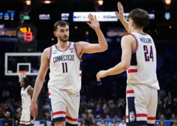 Alex Karaban and Braylon Mullins high-five during a UConn game.