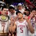 Arkansas players Trevon Brazile, Darius Acuff Jr., and Jaden Karuletwa celebrating their tournament victory with the trophy.