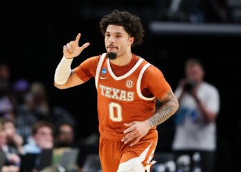 Jordan Pope in a Texas uniform reacts during a basketball game.
