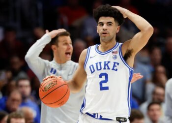 Duke guard Cayden Boozer (2) and head coach Jon Scheyer call a play during a basketball game.
