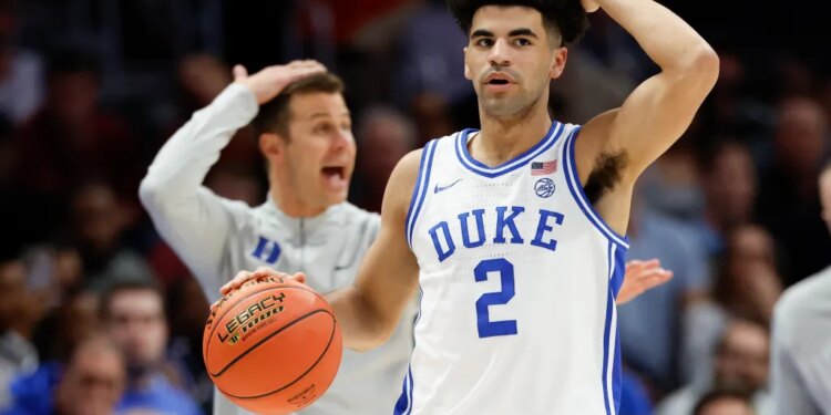 Duke guard Cayden Boozer (2) and head coach Jon Scheyer call a play during a basketball game.