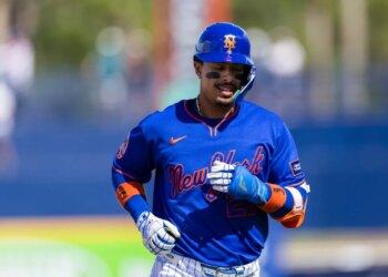 New York Mets infielder Mark Vientos (27) in a blue uniform and helmet with orange "NY" logo and black eye black.