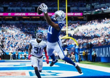 Michael Pittman Jr. jumping to catch a football in the end zone as Kevin Byard approaches.