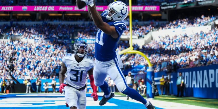 Michael Pittman Jr. jumping to catch a football in the end zone as Kevin Byard approaches.