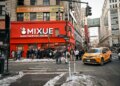 A Mixue coffee shop on Broadway in Koreatown, New York, with a long line of customers outside.