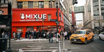 A Mixue coffee shop on Broadway in Koreatown, New York, with a long line of customers outside.