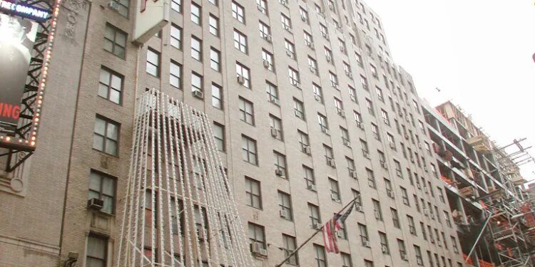 The Hotel Carter building and its entrance marquee from an upward angle, with a taxi driving by.