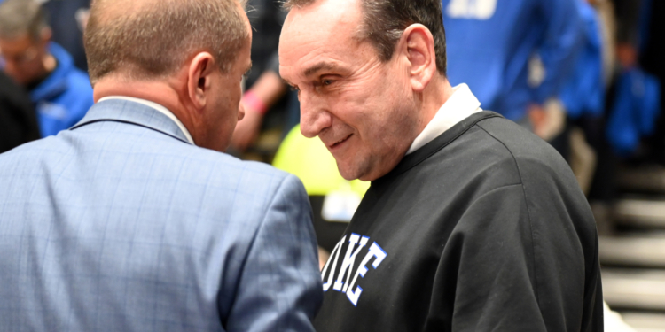 Duke Blue Devils former head coach Mike Krzyzewski chatting with someone in a light blue plaid suit.