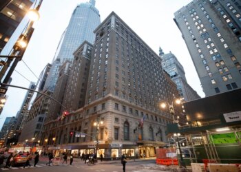 The Roosevelt Hotel in NYC, seen from the street, with pedestrians and cars in the foreground.