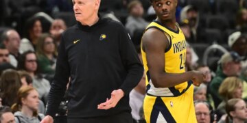 Indiana Pacers coach Rick Carlisle reacts with player Kobe Brown during a basketball game against the Milwaukee Bucks.