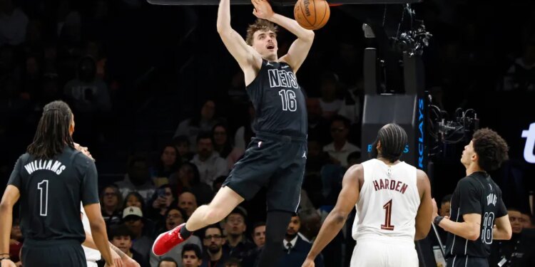 Brooklyn Nets' Grant Nelson slams the ball as Cleveland Cavaliers' James Harden watches.