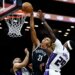 Brooklyn Nets player Noah Clowney (21) shooting over Sacramento Kings players Devin Carter (22) and Daeqwon Plowden (29).