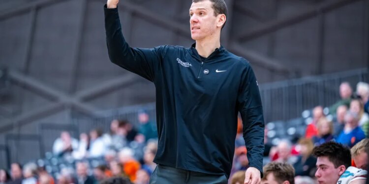Cornell basketball coach gesturing courtside.