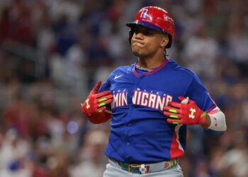 Dominican Republic left fielder Juan Soto (22) in a red batting helmet and blue jersey reacts after hitting a two-run home run.