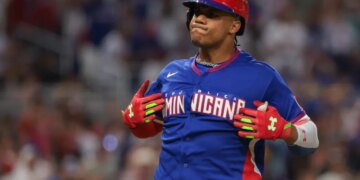 Dominican Republic left fielder Juan Soto (22) in a red batting helmet and blue jersey reacts after hitting a two-run home run.