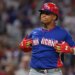 Dominican Republic left fielder Juan Soto (22) in a red batting helmet and blue jersey reacts after hitting a two-run home run.