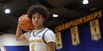 Hofstra basketball player Preston Edmead holding a basketball on his shoulder, with "Championships" banners in the background.