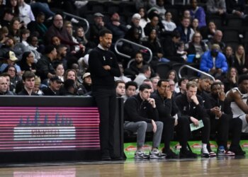 Providence Friars head coach Kim English observing the game from the sidelines.