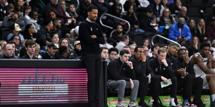 Providence Friars head coach Kim English observing the game from the sidelines.