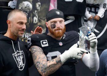 Las Vegas Raiders defensive end Maxx Crosby (98) lifts his award as general manager John Spytek, left, looks on after receiving the Walter Payton Man of the Year Award before a game against the Denver Broncos at Allegiant Stadium on Dec. 7, 2025, in Las Vegas.