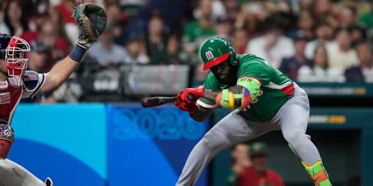 Randy Arozarena batting, with a catcher behind him and a baseball in the air.