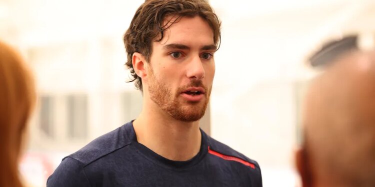 New York Rangers rookie Dylan Garand in a navy blue shirt with a red stripe.
