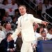 St. John’s head coach Rick Pitino in a white suit, gesturing during a game.