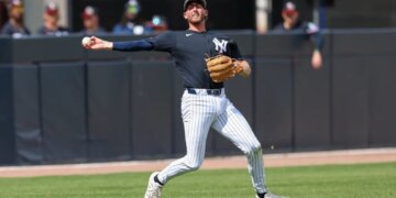 New York Yankees shortstop Ryan McMahon (19) throwing to first base.