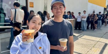 Two people holding Skims x Community Goods latte cups.
