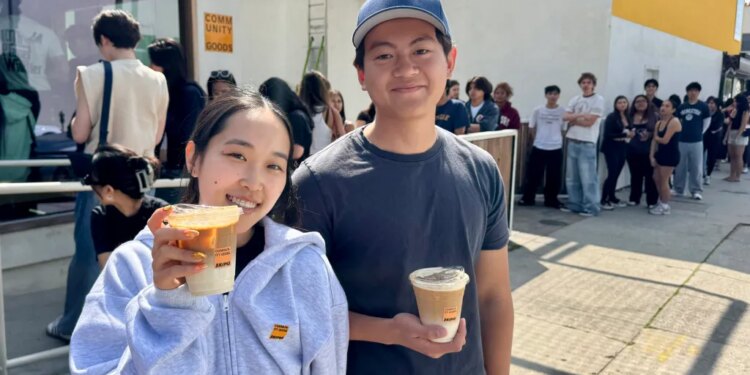 Two people holding Skims x Community Goods latte cups.