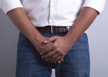 Man covering his groin area with his hands.