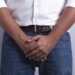 Man covering his groin area with his hands.