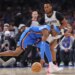 Oklahoma City Thunder guard Shai Gilgeous-Alexander, center, tries to keep control of the ball against San Antonio Spurs guard Stephon Castle (5).