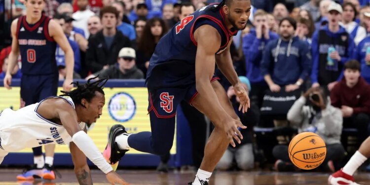 Zuby Ejiofor of St. John's stealing the ball from A.J. Staton-McCray of Seton Hall during an NCAA basketball game.
