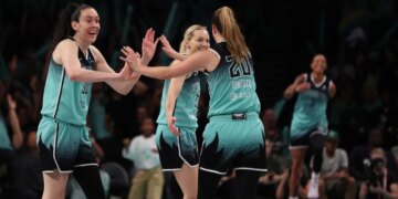 New York Liberty players Breanna Stewart and Sabrina Ionescu high-five during a game against the Phoenix Mercury.