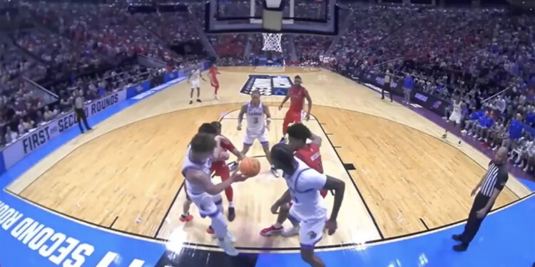 Basketball players in white and red jerseys on a court during a March Madness game.