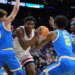 UConn's Tarris Reed Jr. holding the basketball, surrounded by UCLA players Trent Perry, Donovan Dent, and Eric Dailey Jr.