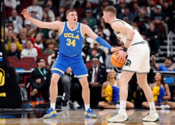 UCLA star Tyler Bilodeau guarding an opposing player with a basketball.