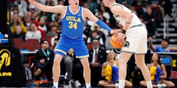 UCLA star Tyler Bilodeau guarding an opposing player with a basketball.
