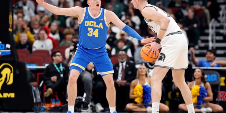 UCLA star Tyler Bilodeau guarding an opposing player with a basketball.