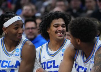 UCLA basketball player Skyy Clark smiles while missing a front tooth and with blood on his gum.