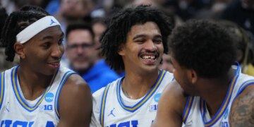 UCLA basketball player Skyy Clark smiles while missing a front tooth and with blood on his gum.