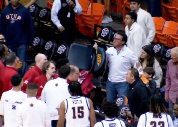 An angry UTEP fan picks up a chair and gestures toward Jacksonville State players after a men's college basketball game on March 7, 2026.
