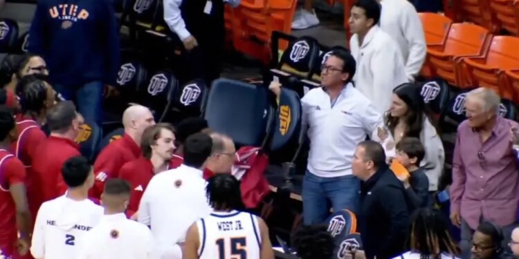 An angry UTEP fan picks up a chair and gestures toward Jacksonville State players after a men's college basketball game on March 7, 2026.