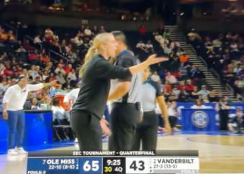 A coach argues with a referee on a basketball court during an SEC Tournament game between Ole Miss and Vanderbilt.